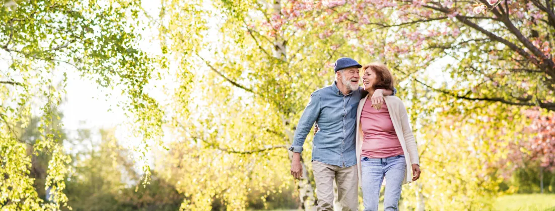 Happy couple strolling through blossoming trees.